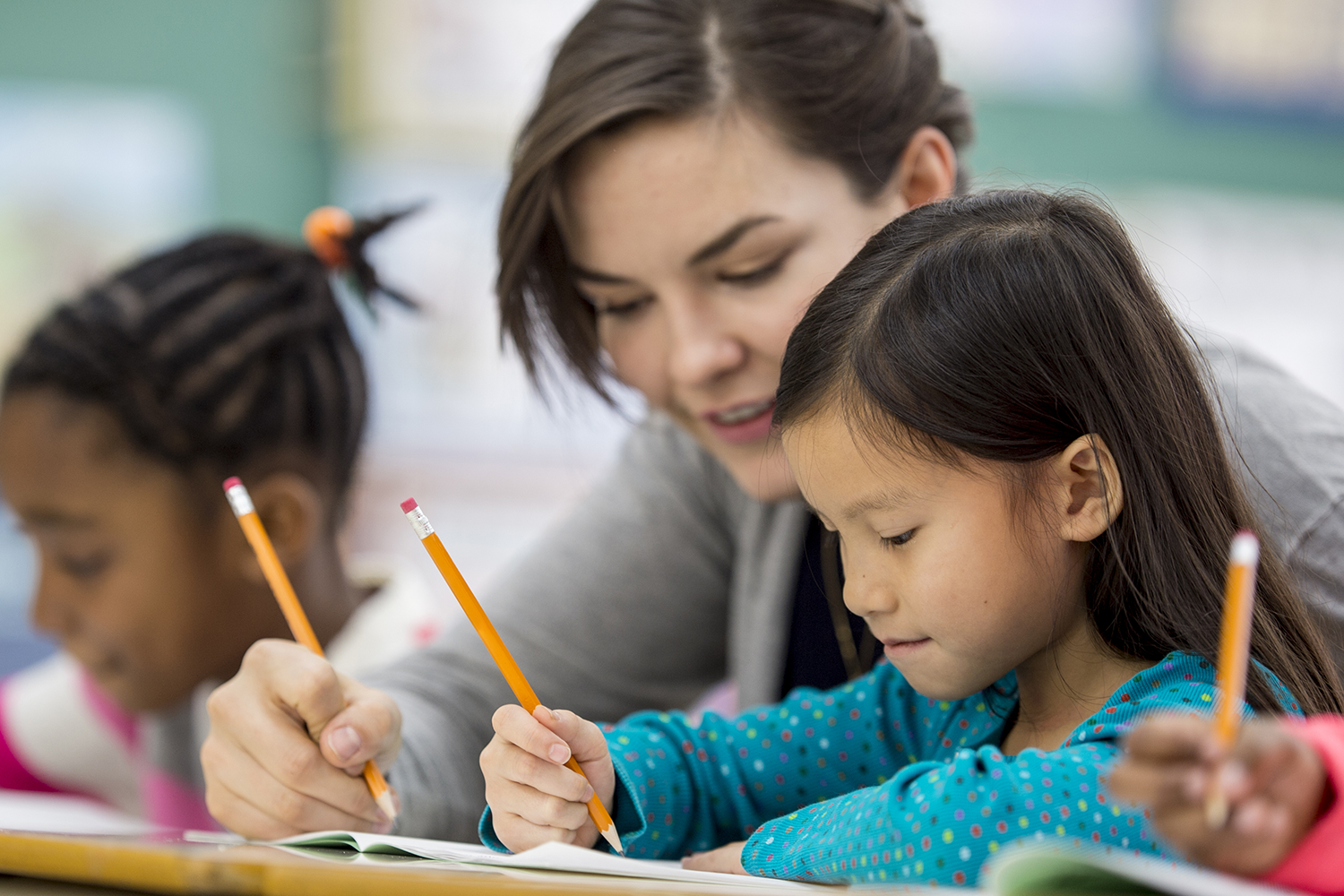 Teacher helps elementary aged student with writing skills.