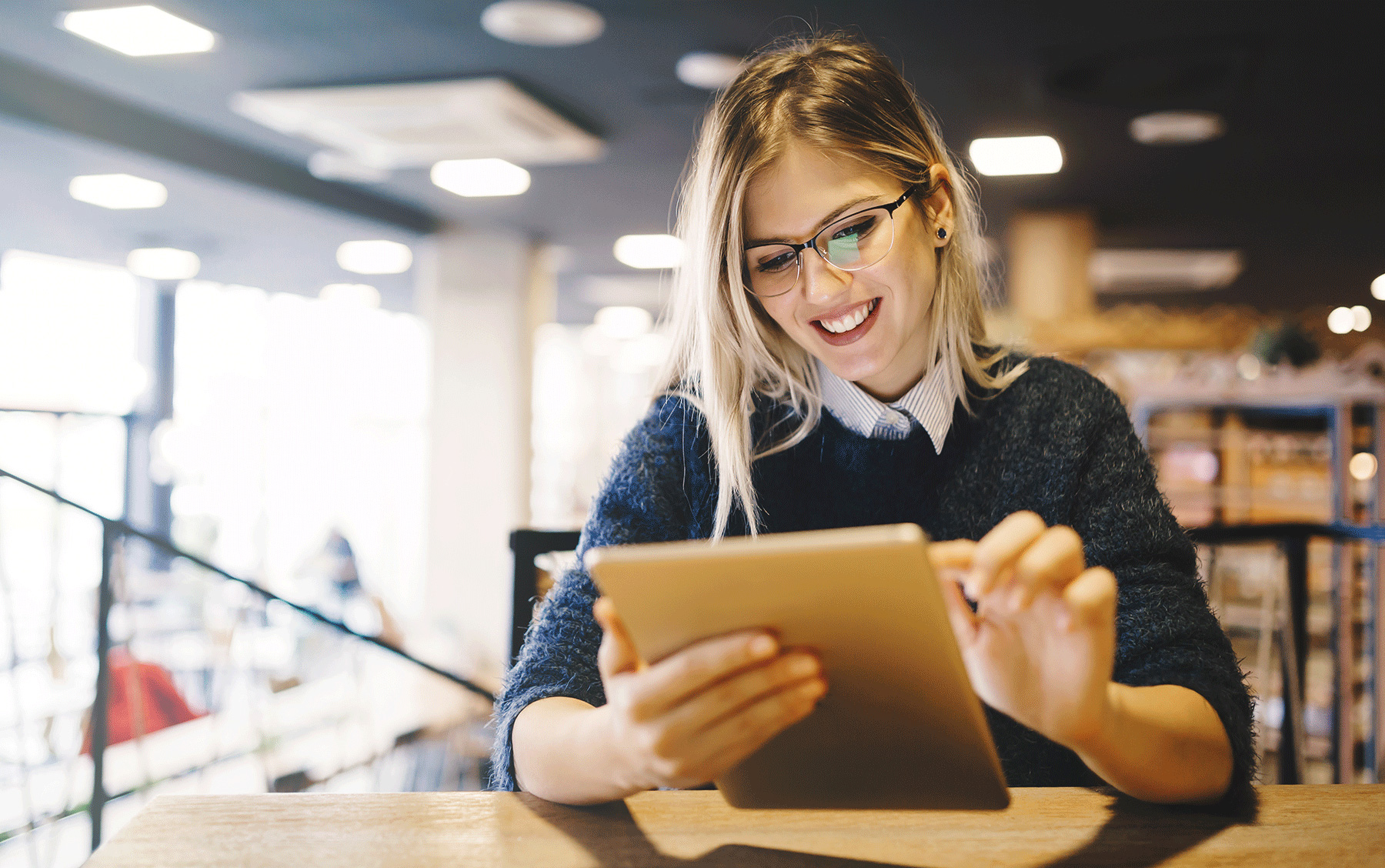 female student studying on tablet in library setting
