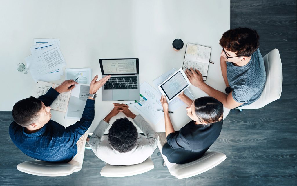 colleagues viewed from overhead at table on laptops