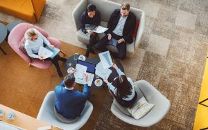 group of colleagues viewed from overhead meeting in lounge