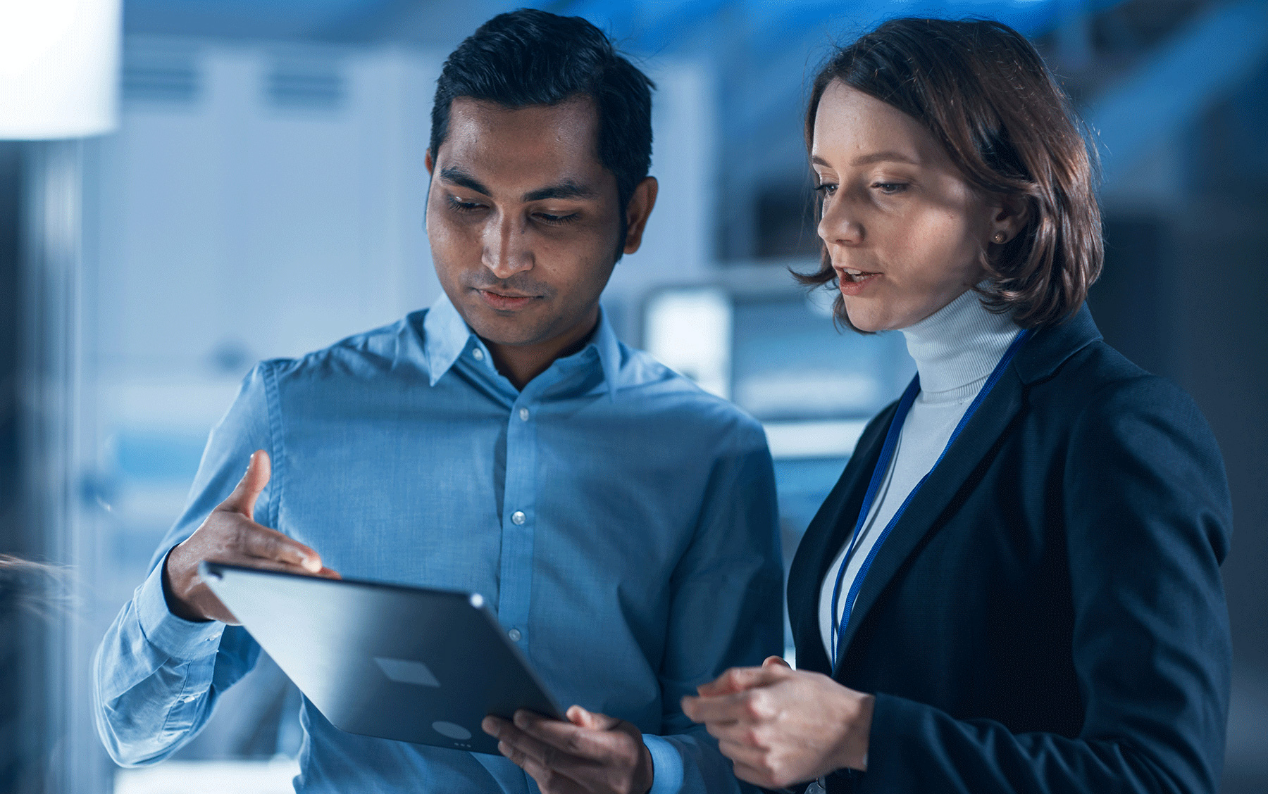 two colleagues view content on a tablet device