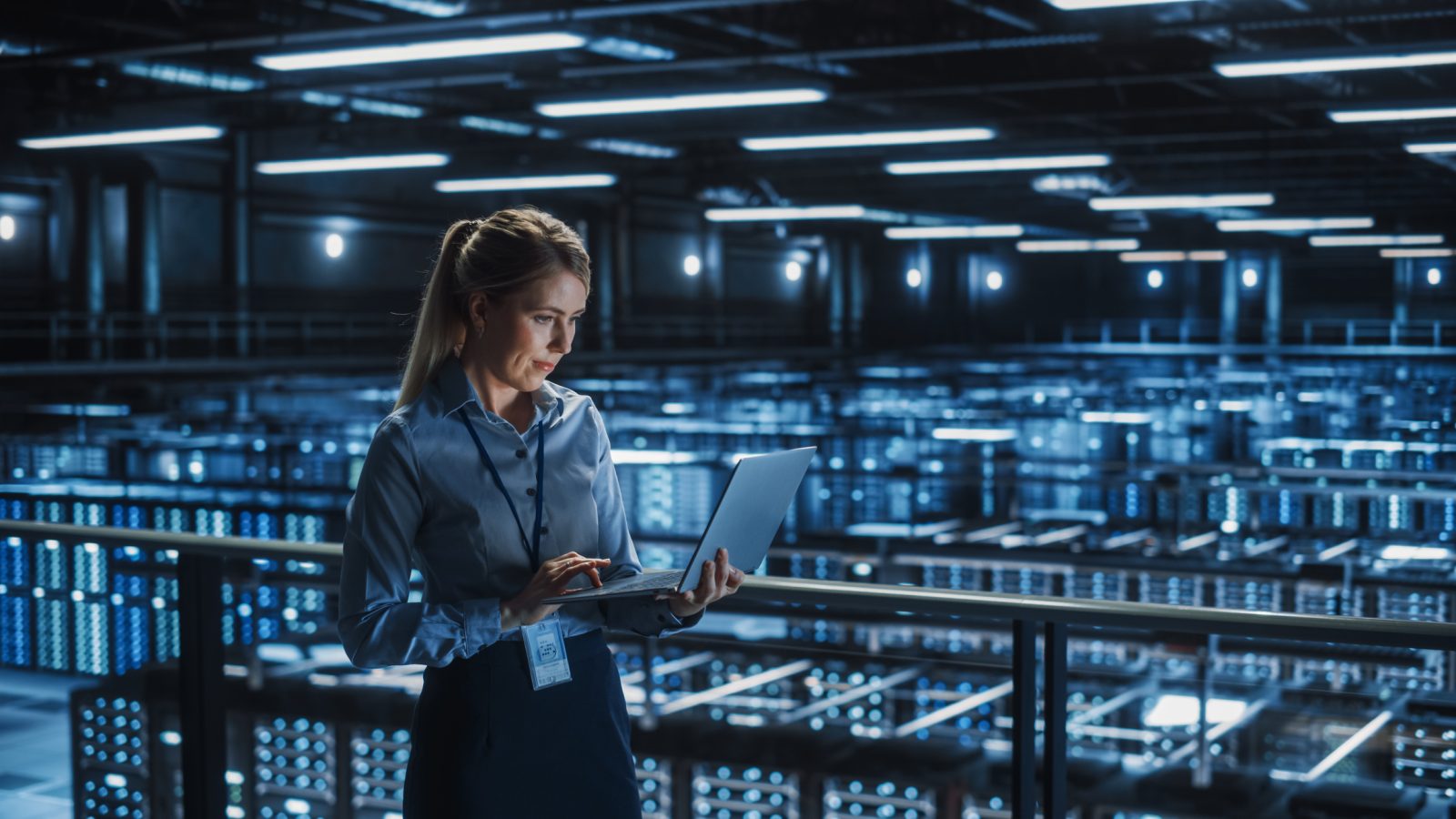 female IT worker examines data on laptop in lab