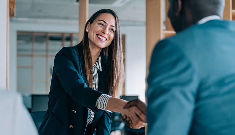 Two people smiling and shaking hands