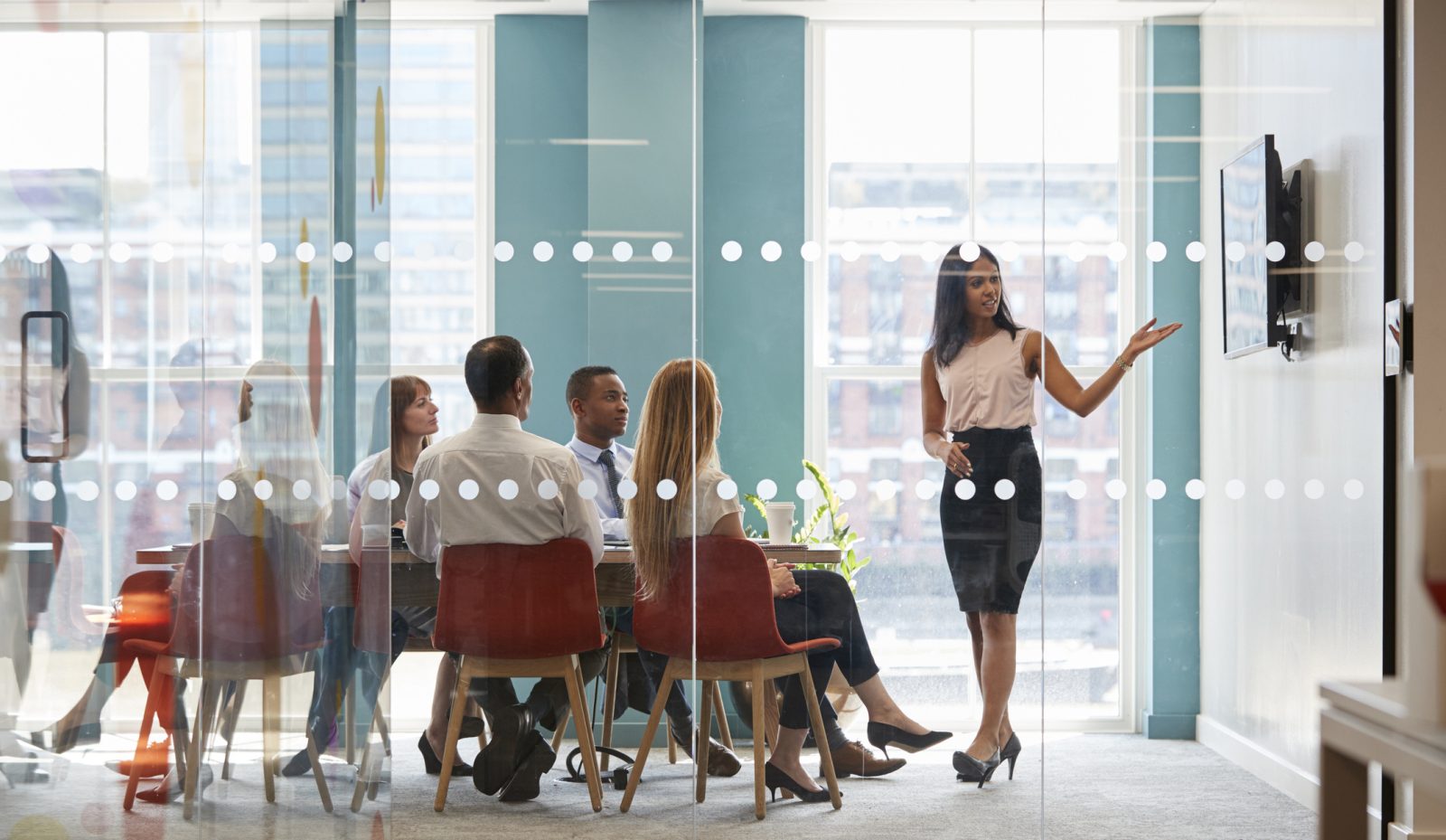 Female boss shows presentation on screen at business meeting