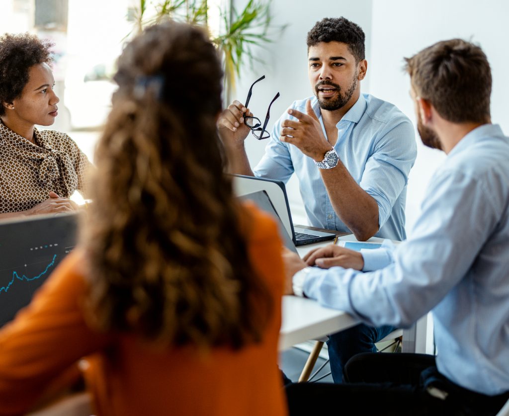 business people listen to colleague make a point in a meeting