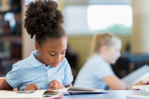 schoolgirl reading a book in the library