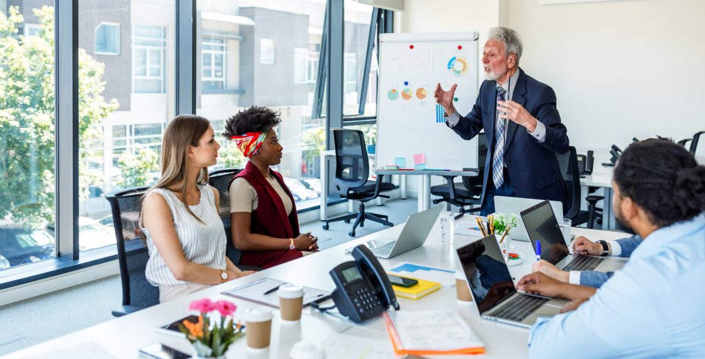 businessman explaining graphs to the rest of his colleagues