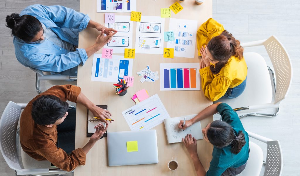 Top view of developer sand ui designers brainstorming about mobile app interface during a meeting