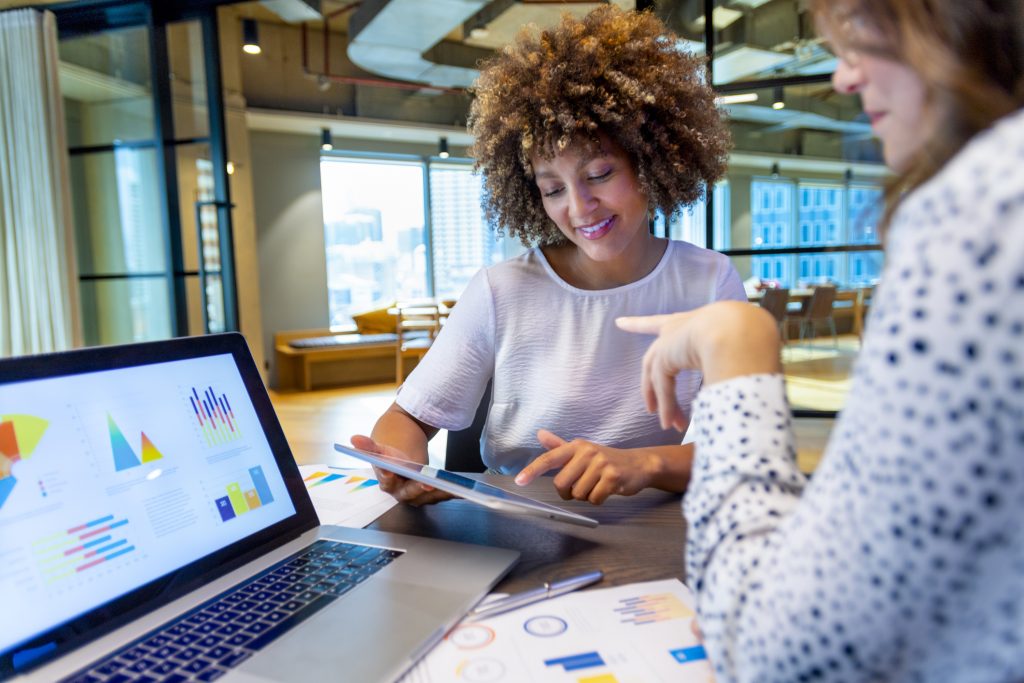 two women having a conversation about finance charts and graphs