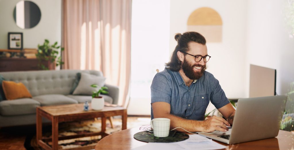 Shot of a young businessman using his laptop to work from home