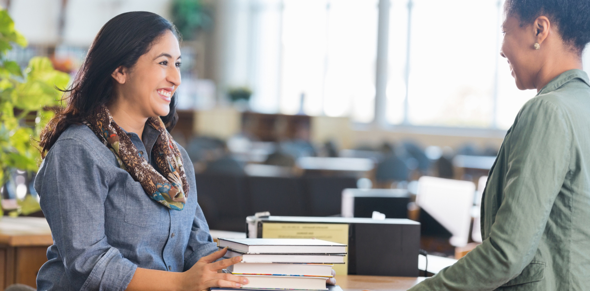 Adult student checking out books in local college library