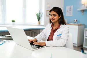 woman working in medical jacket on laptop