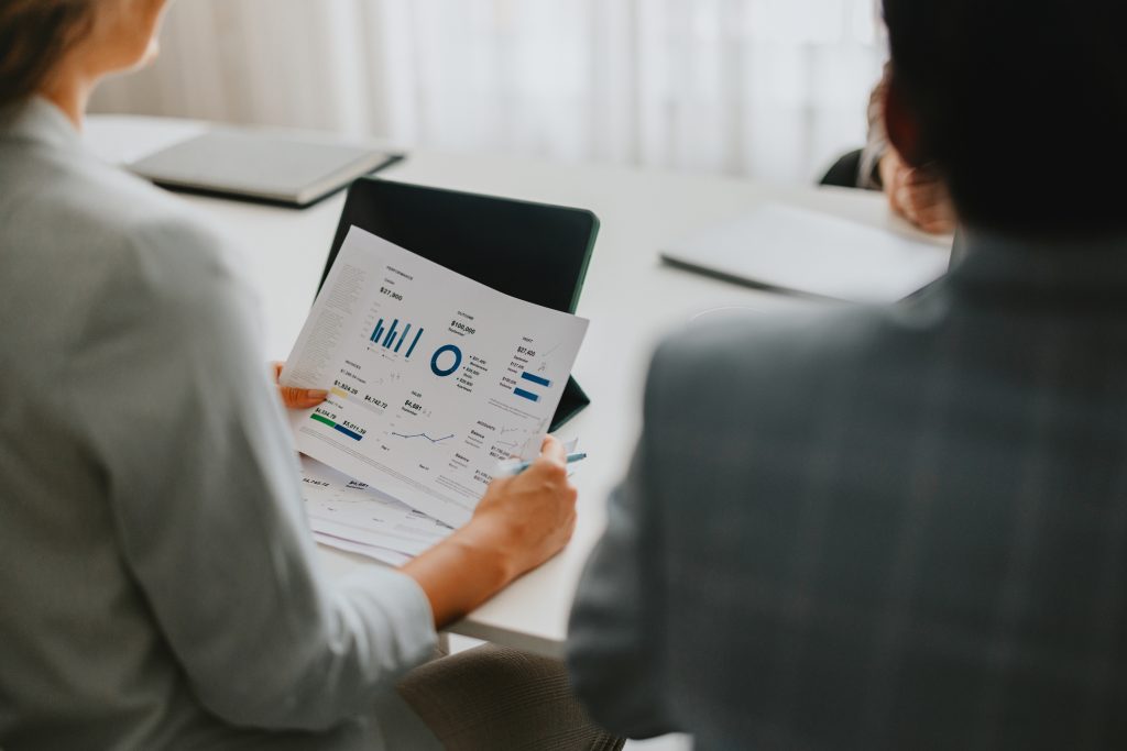 two professional business employees reviewing financial charts and documents