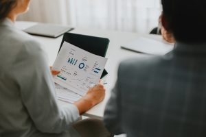 two professional business employees reviewing financial charts and documents